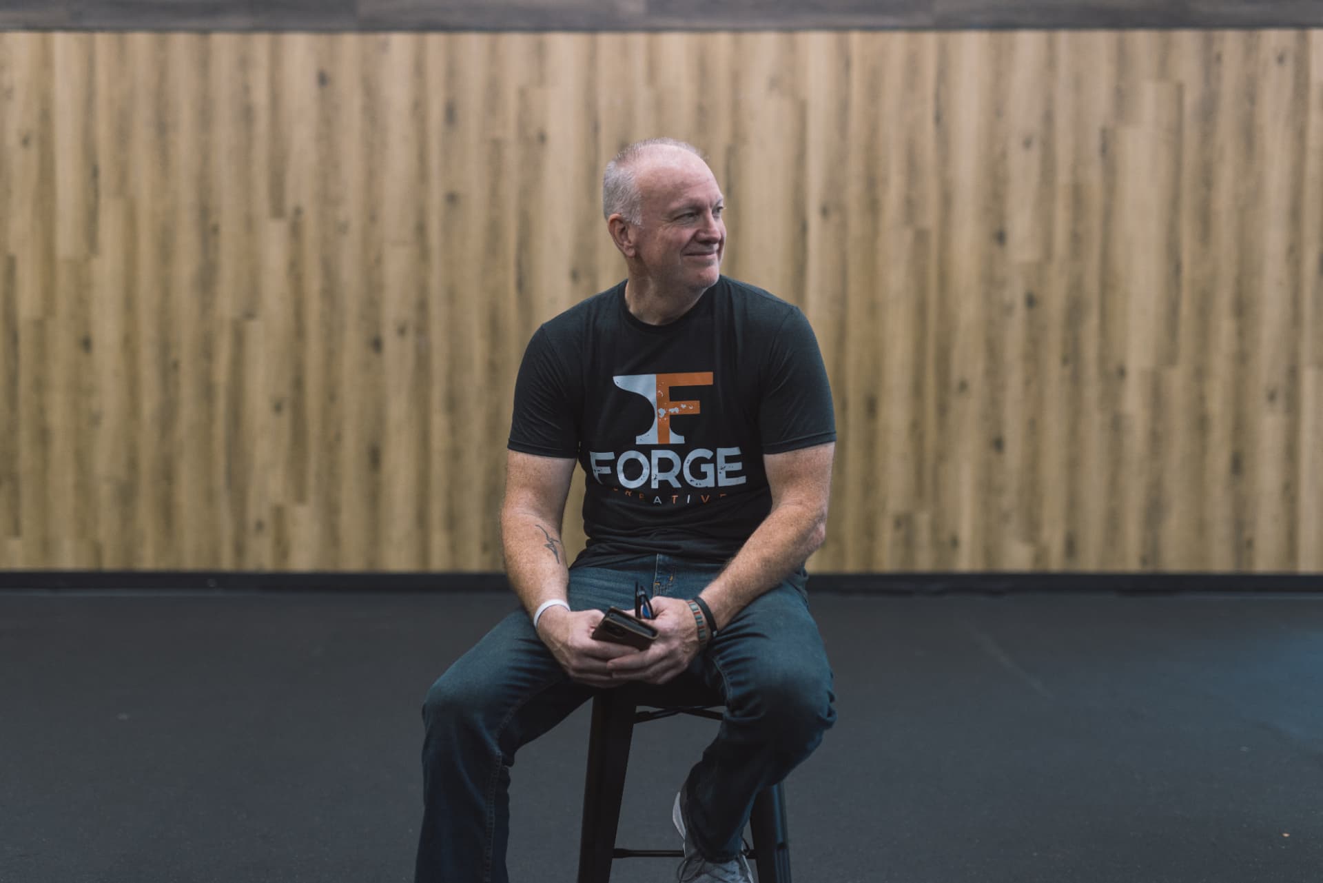 Jeff Mason seated on a stool in the Forge studio space